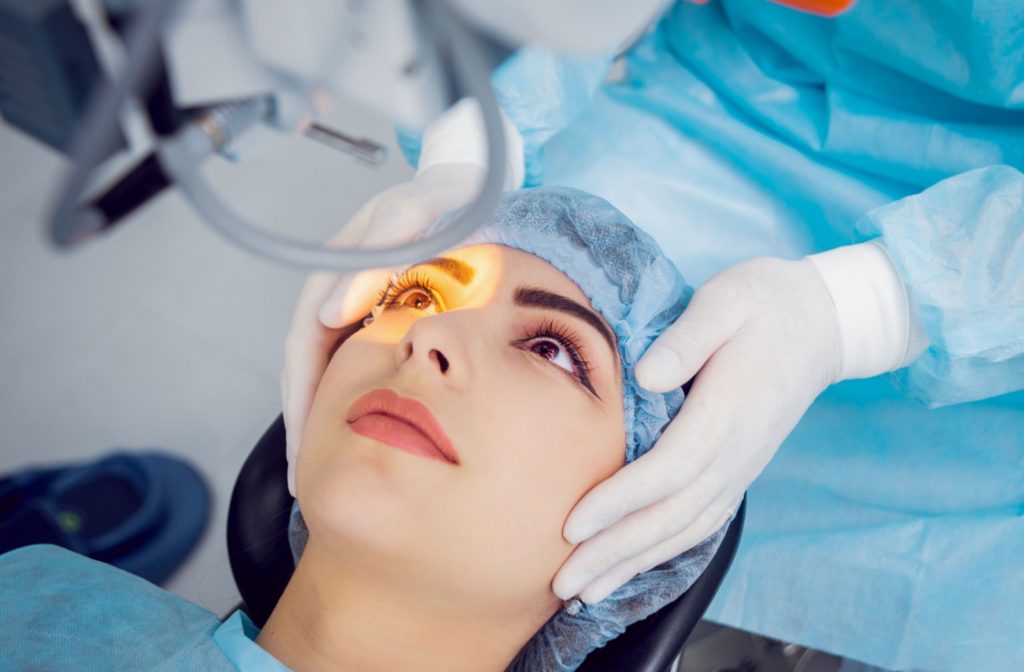 Close up of a young woman's face looking into a light as her eye doctor prepares her for laser eye surgery
