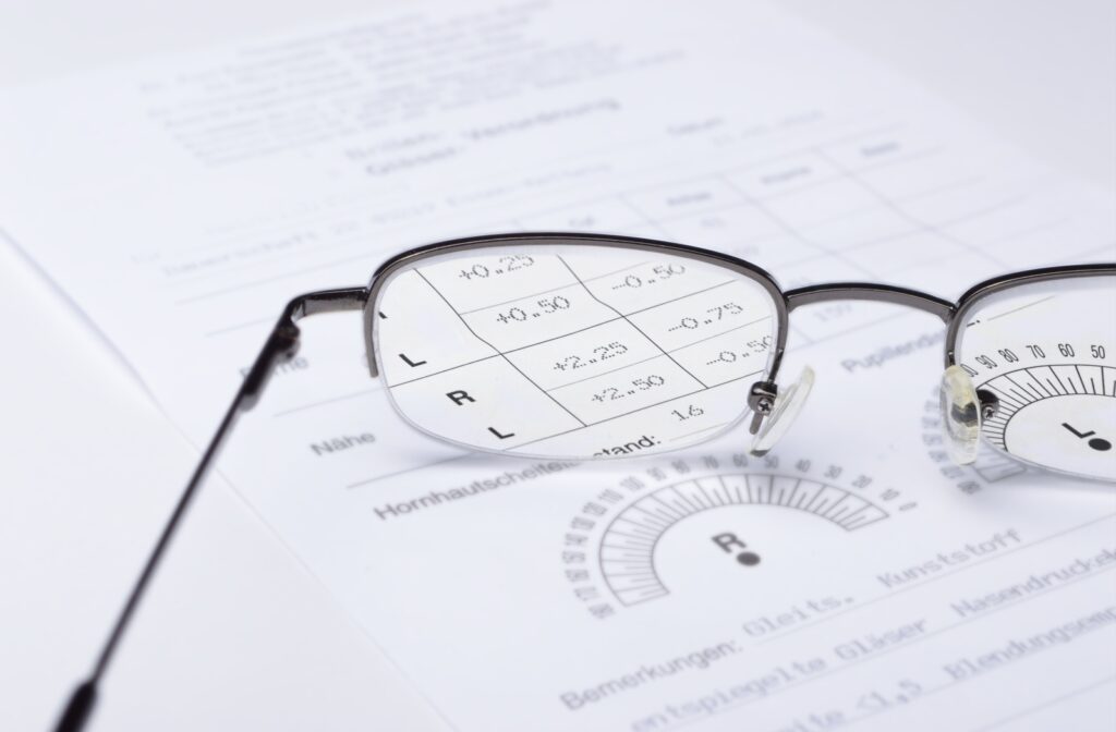The lenses from a pair of eyeglasses magnify the values of a vision prescription.