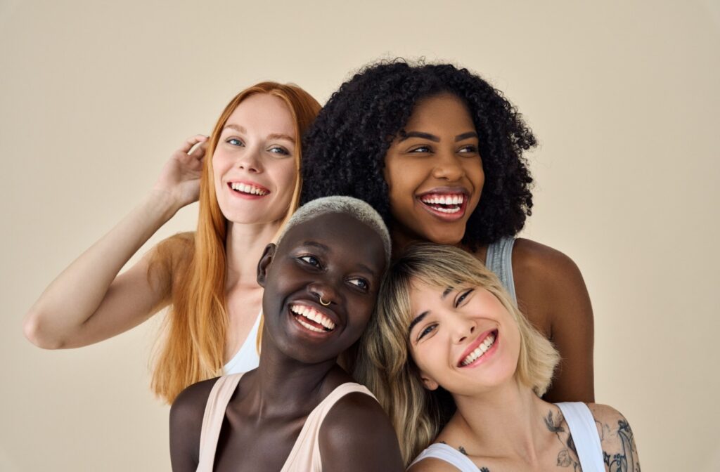 Four people with different face shapes smiling and laughing together.