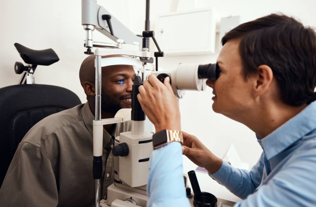 Optometrist performing an eye examination using a slit-lamp to closely inspect a patient’s eye for signs of disease or irregularities in a clinical setting.