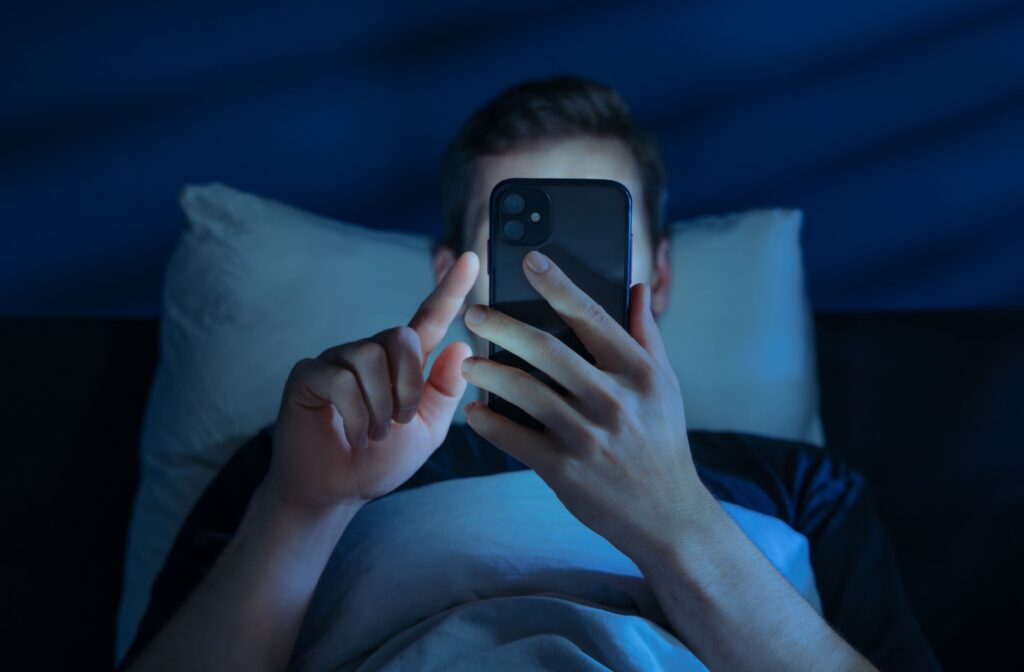A person using their phone in a dark room.