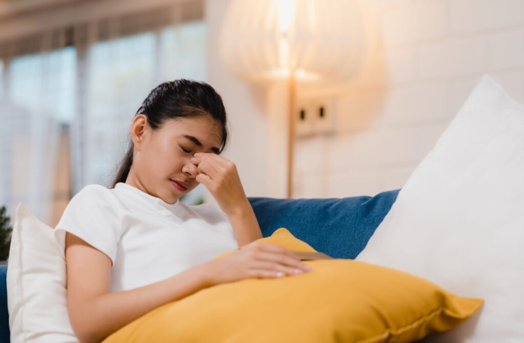 A person pinching in between their eyes as they feel eye pain