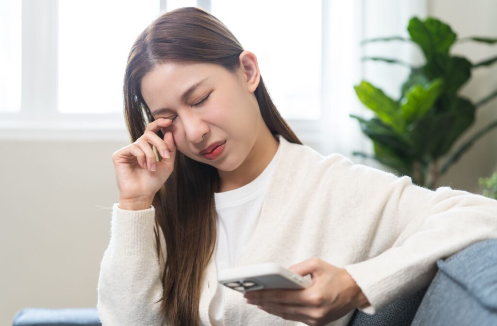 A person rubbing their eyes that are experiencing pain
